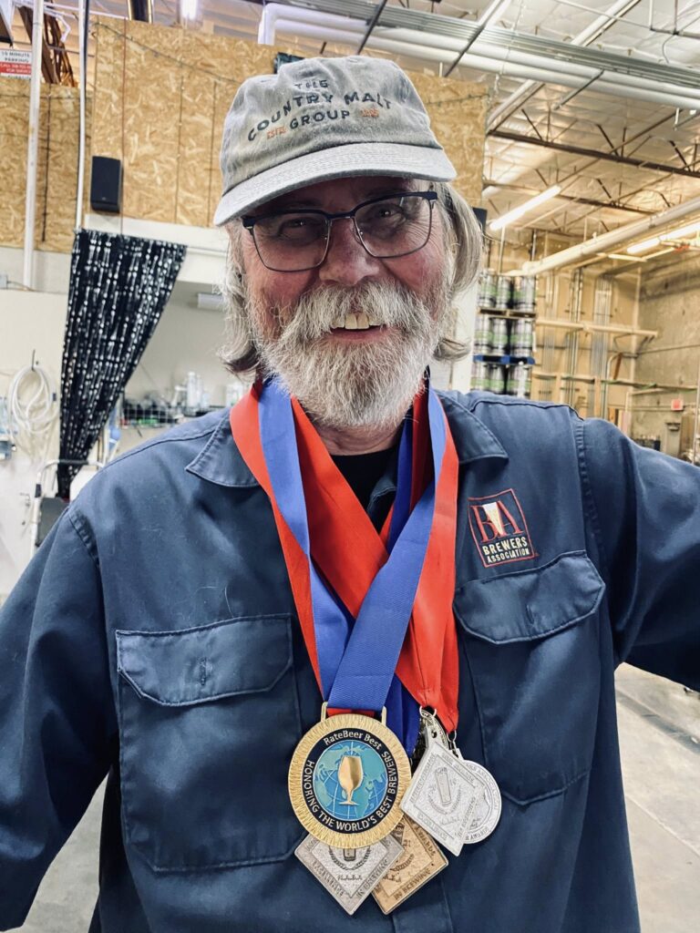 Brewer Jerry Larson with many medals on ribbons around his neck.