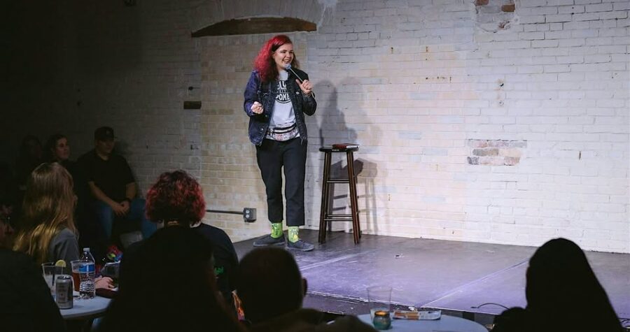 Photo of Hailee on stage performing stand up comedy